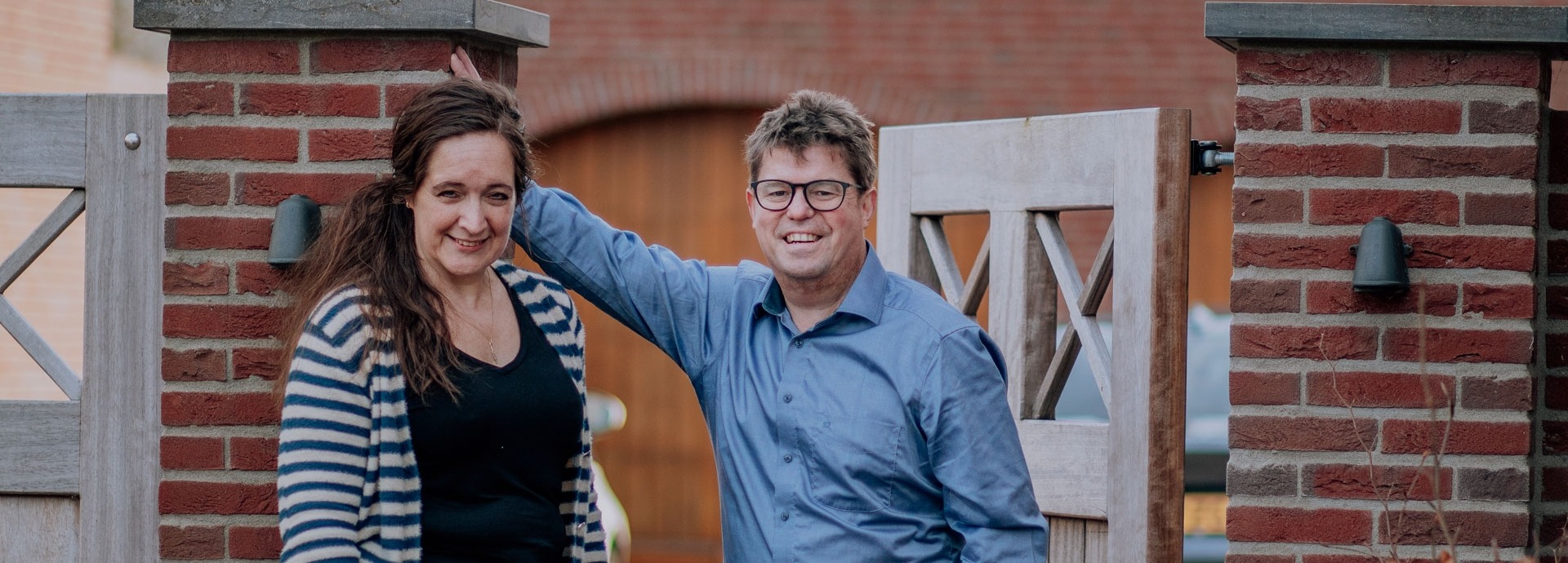 Ruud en Jacqueline staan bij een hek voor een woning
