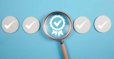 Kwaliteit controle concept; vier icoontjes met een vinkje op een blauwe achtergrond waarvan 1 icoontje een certificaat heeft